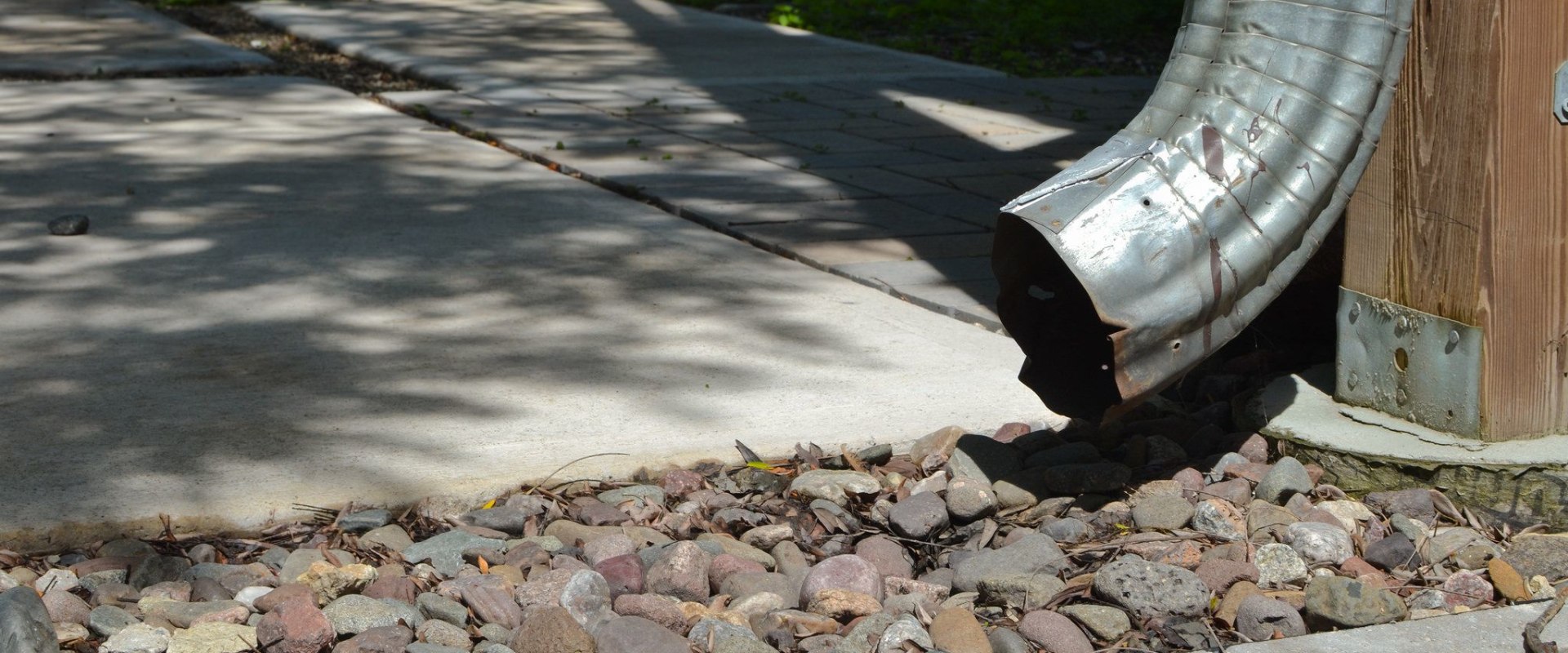 Should gutter downspouts touch the ground?